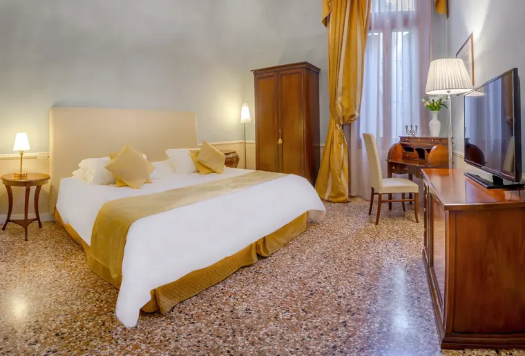 Superior room at Palazzo Vitturi with golden drapes and writing desk