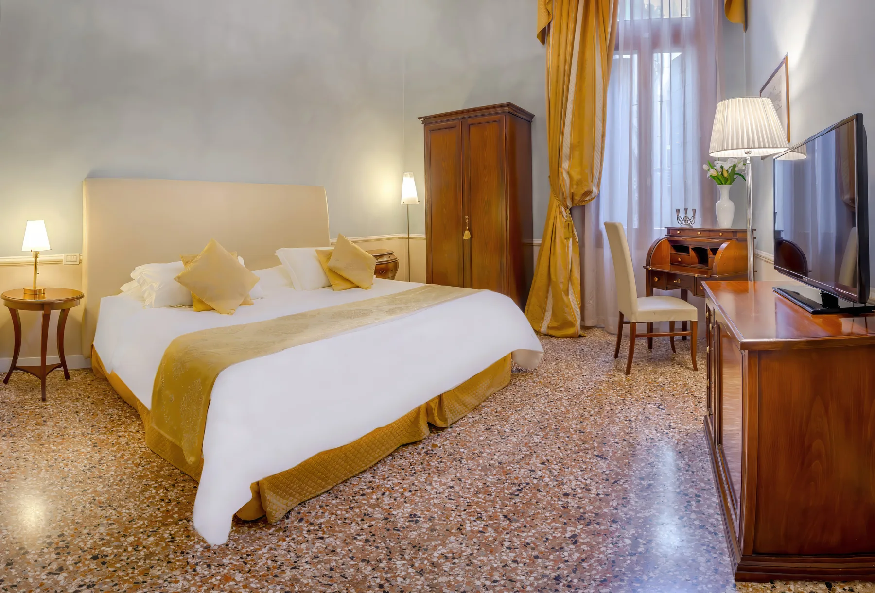 Superior room at Palazzo Vitturi with golden drapes and writing desk