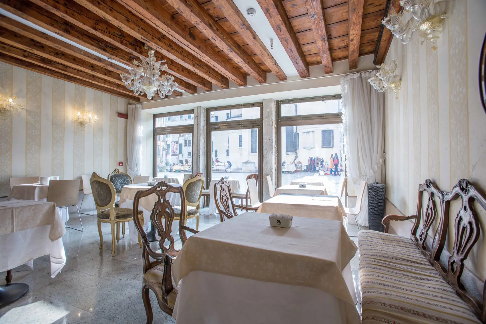 The breakfast room at Palazzo Vitturi with exposed beams and a Murano chandelier