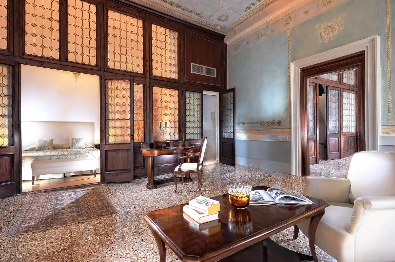 The noble lounge of Palazzo Vitturi with beamed ceiling, gilded mirrors and classic sofas